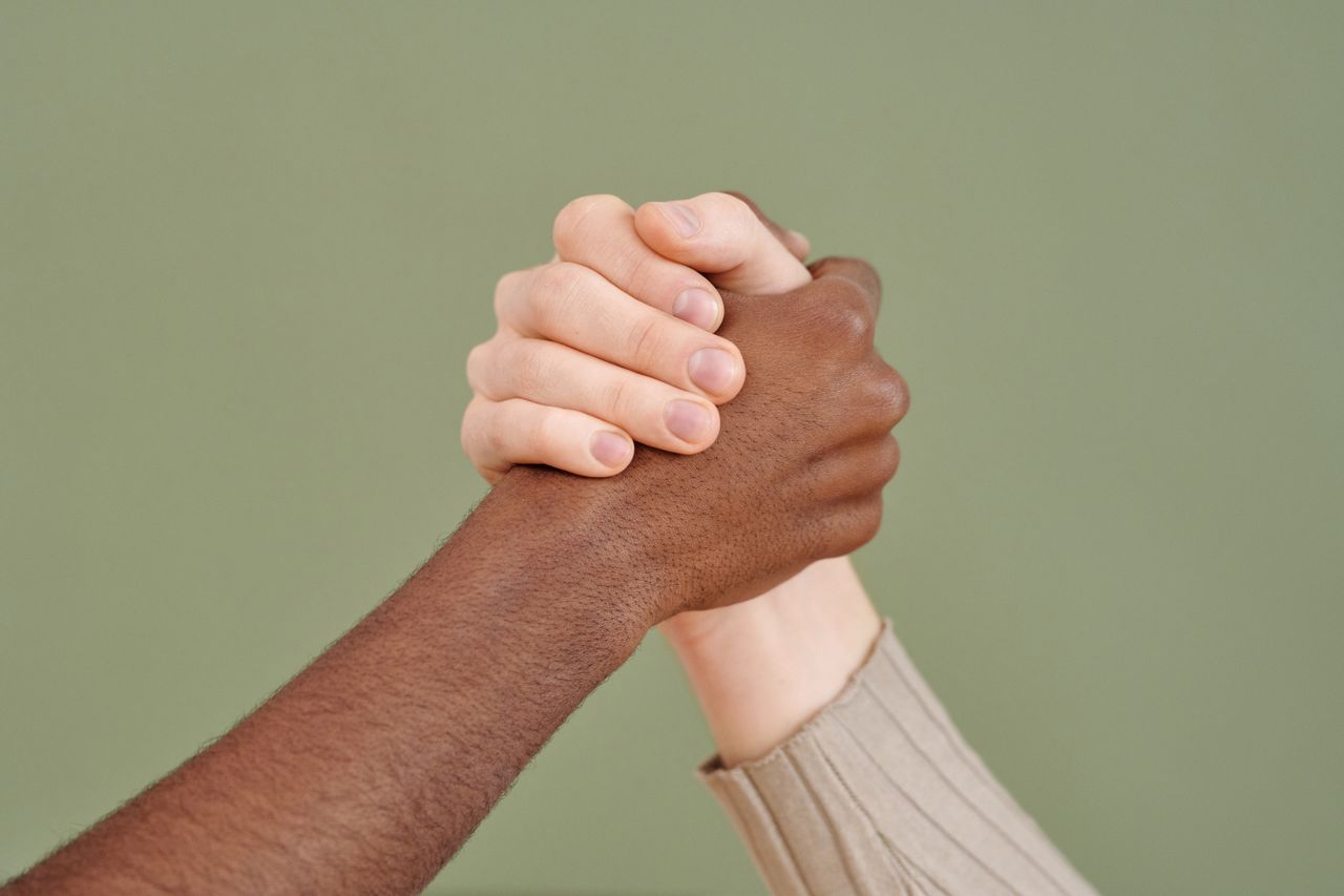 Close-up of diverse hands shaking, symbolizing unity and cooperation.