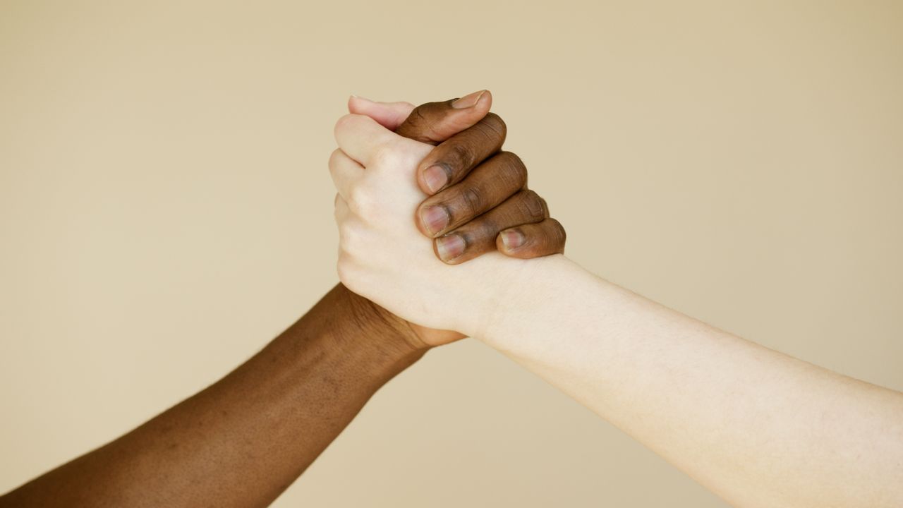 Close-up of two hands clasped representing unity and friendship.